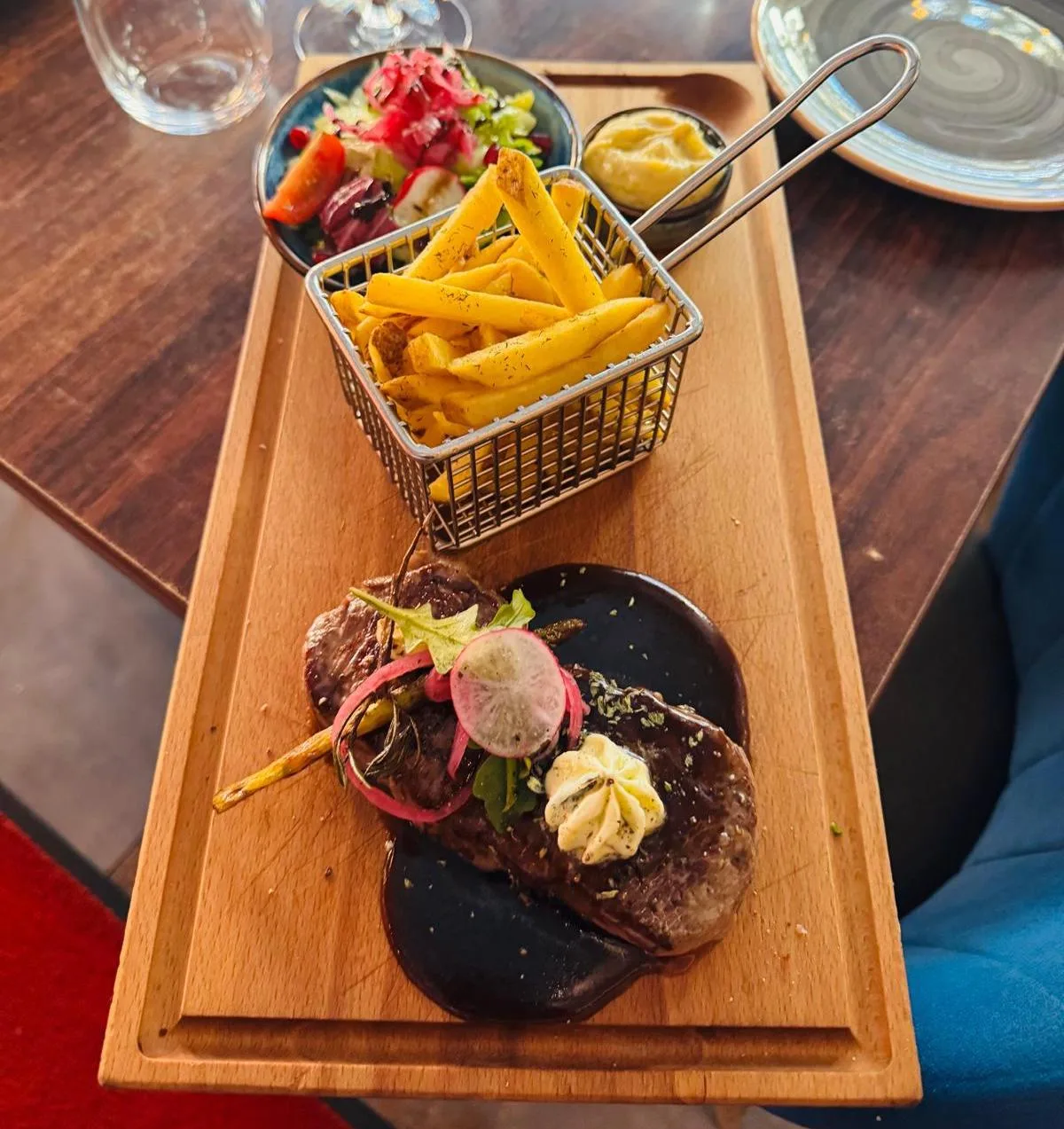 Black Angus-biff med vitlökssmör och pommes på träbricka